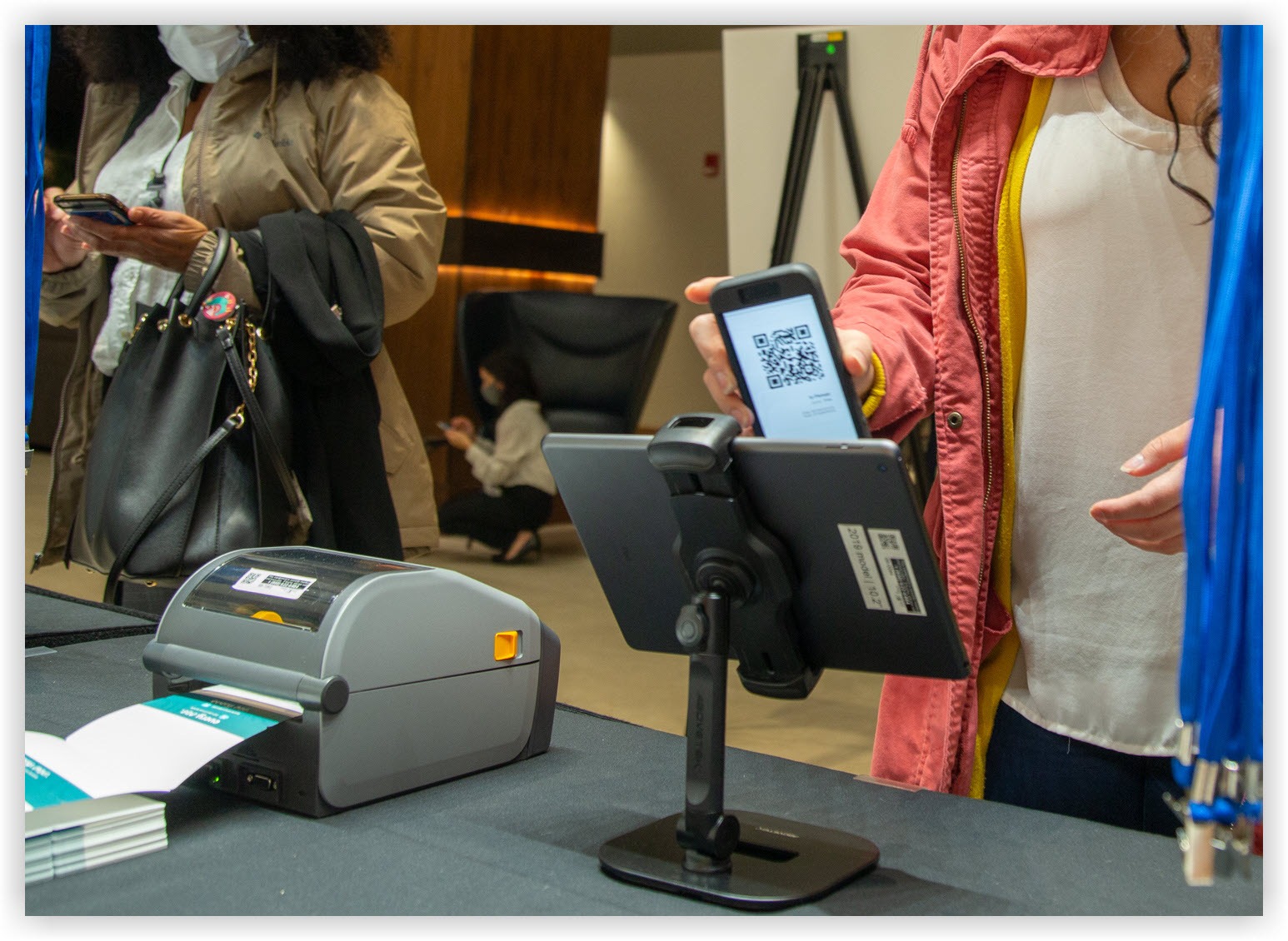 A person scanning a QR code at a check-in iPad.