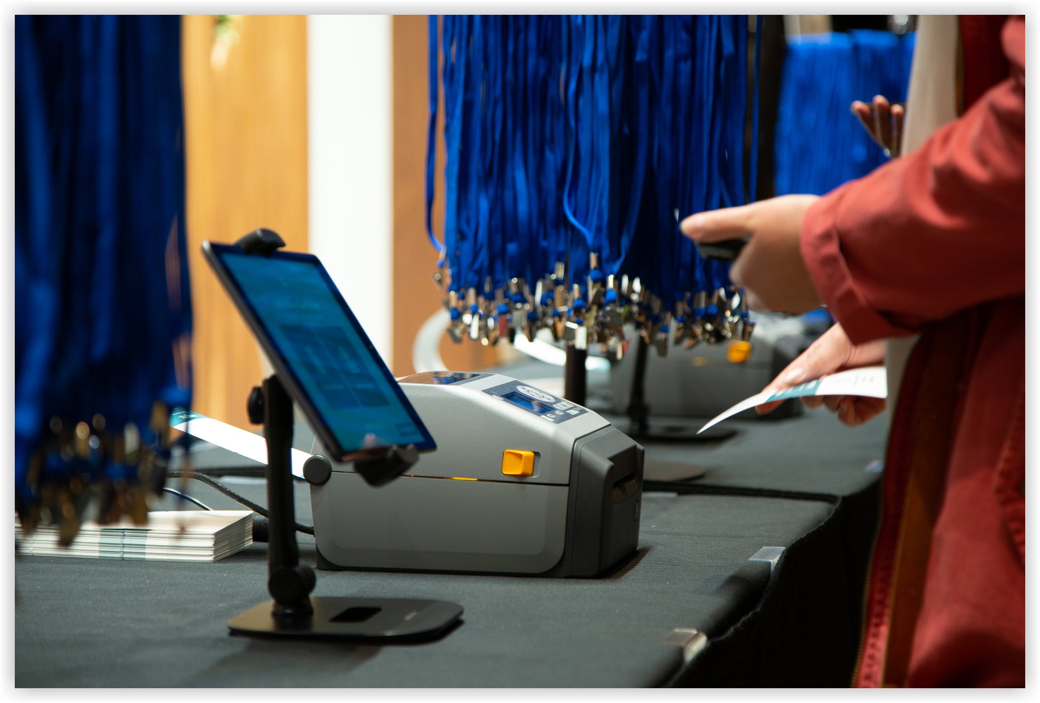 Picture of an iPad on a stand next to a badge printer.
